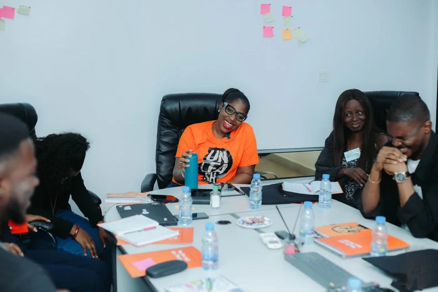 Topsy Kola-Oyeneyin laughing with Envoys around a table